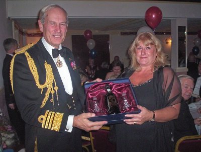 Admiral Boyce presents the winning raffle prize to Julie Brown